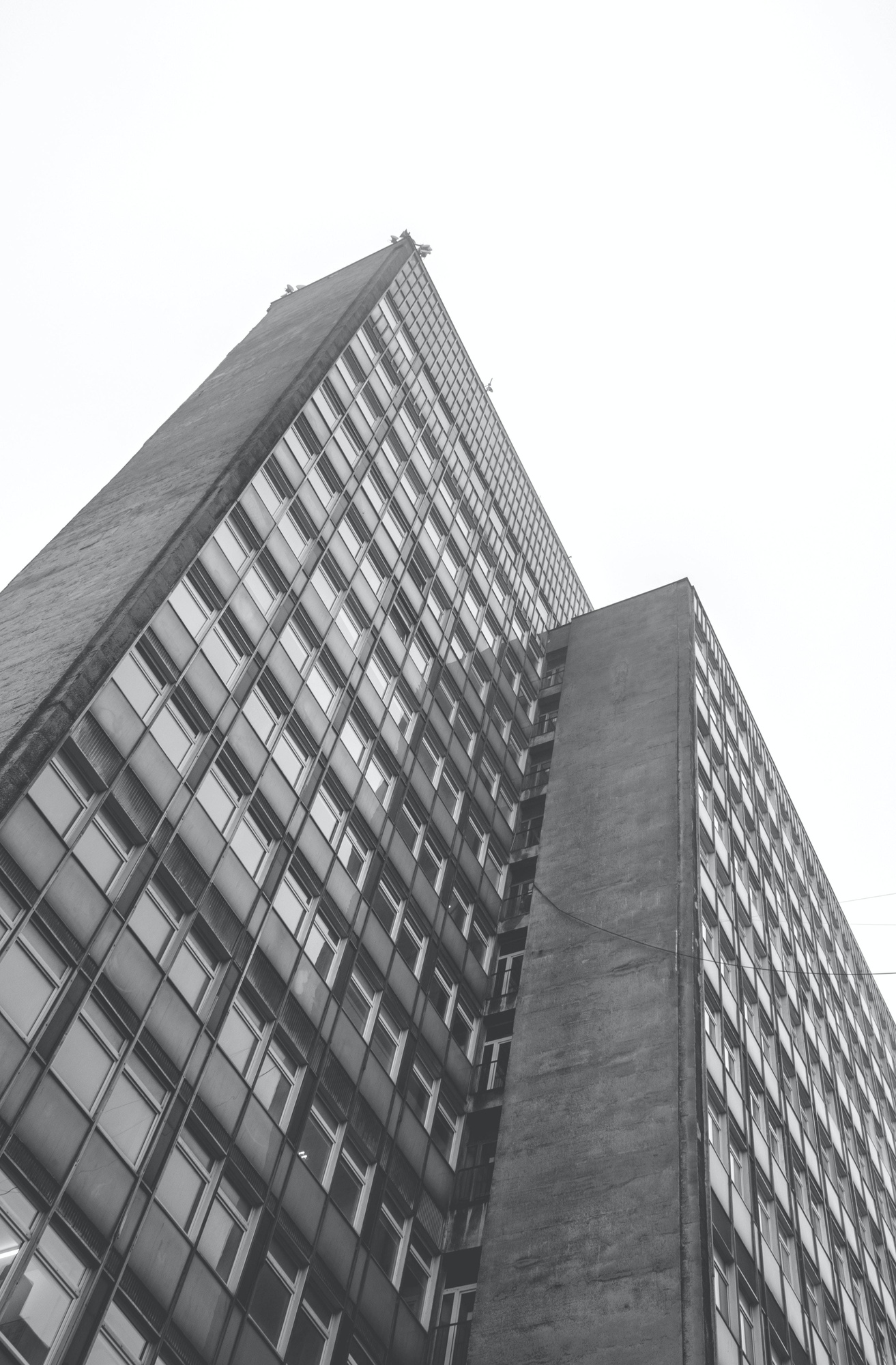vertical-greyscale-low-angle-shot-residential-building-daytime_181624-25398